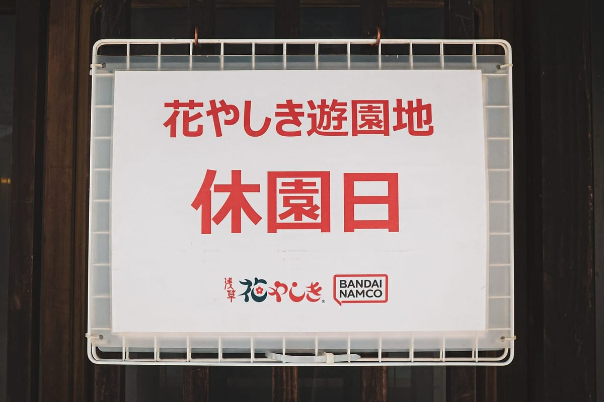 A 休園日 (closed day) sign at the Hanayashiki gate — the sight you want to avoid by checking the calendar