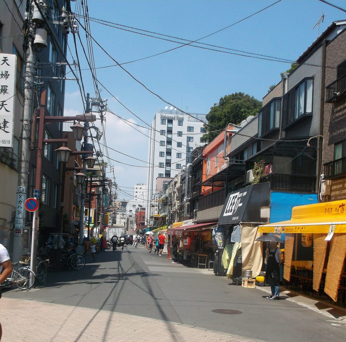 The Hoppy Street lane in Asakusa with izakaya tables set out under awnings